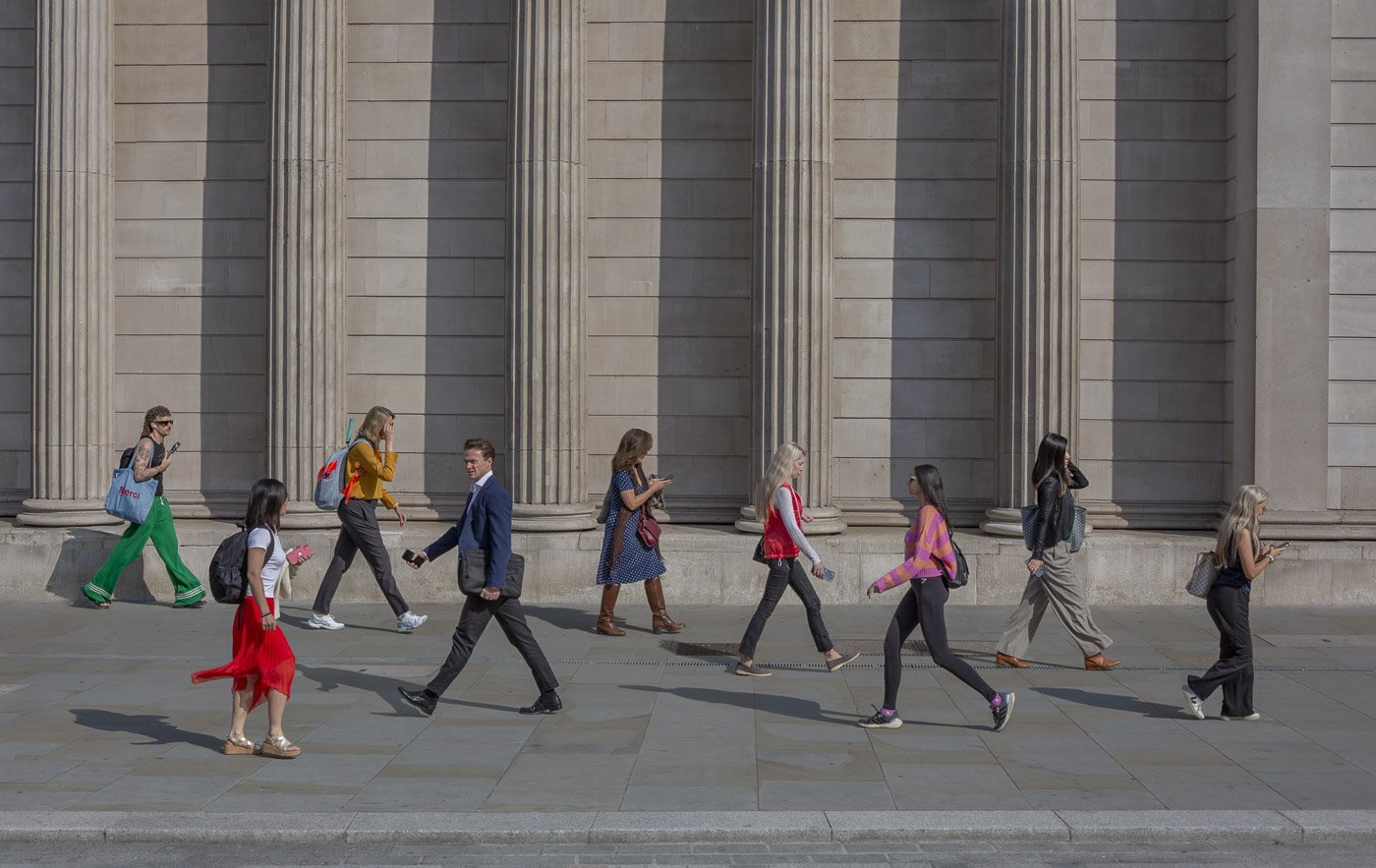 Commuters crossing outside Bank in London, with two individuals sharing a brief glance – photograph by Antony Zacharias.